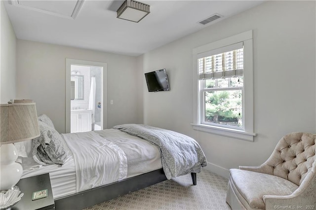 bedroom with light colored carpet and ensuite bathroom