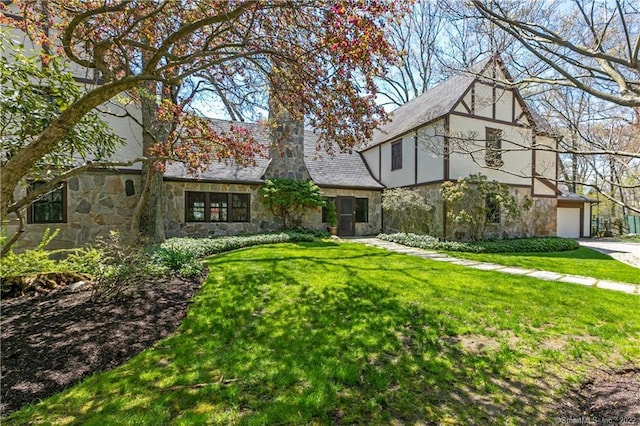 tudor-style house with a garage and a front lawn