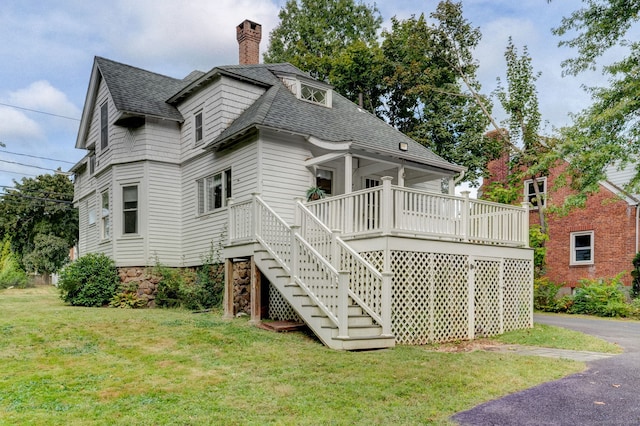 exterior space featuring a wooden deck and a lawn