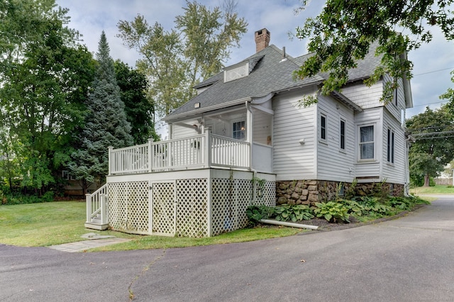 exterior space with a wooden deck and a lawn