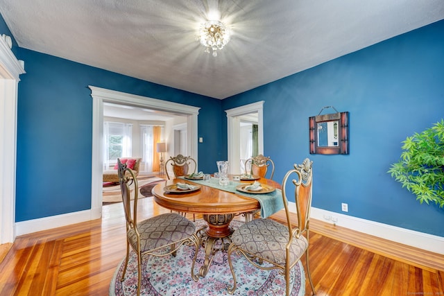 dining room featuring a textured ceiling and light hardwood / wood-style flooring