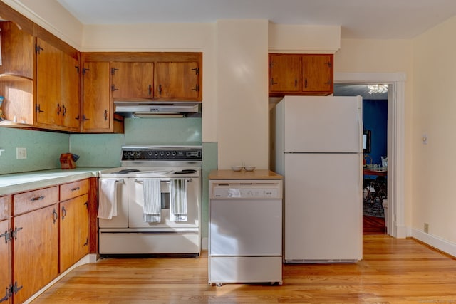 kitchen featuring white appliances, light hardwood / wood-style floors, and tasteful backsplash