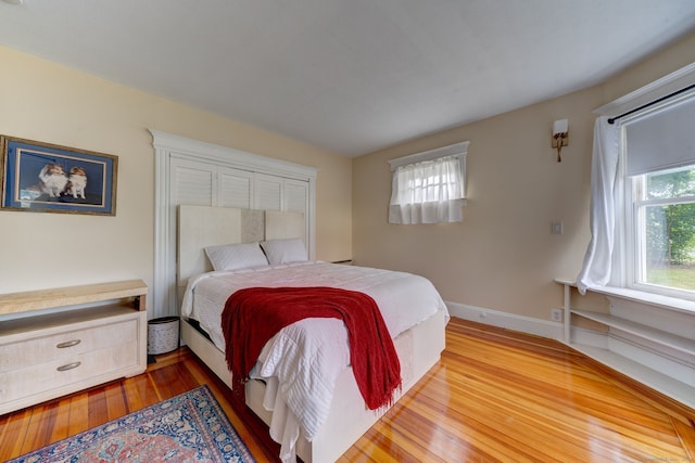 bedroom with hardwood / wood-style floors and multiple windows