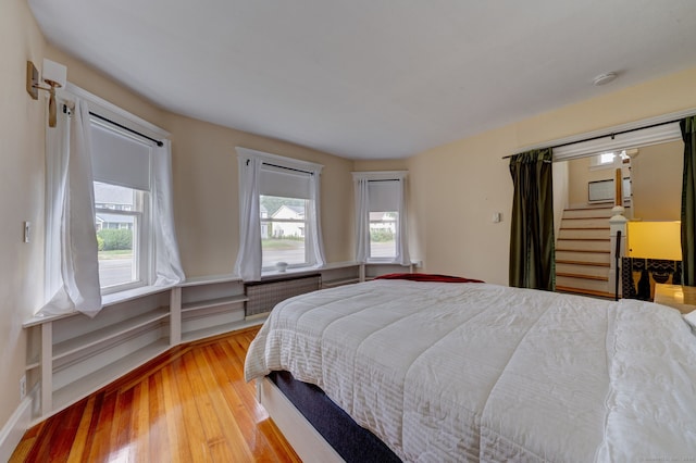 bedroom with multiple windows and hardwood / wood-style floors