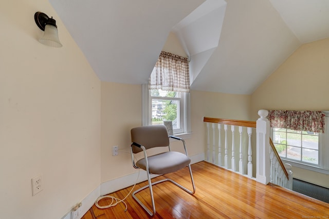 living area featuring wood-type flooring, vaulted ceiling, and plenty of natural light