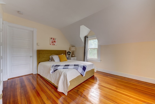 bedroom featuring vaulted ceiling and hardwood / wood-style flooring