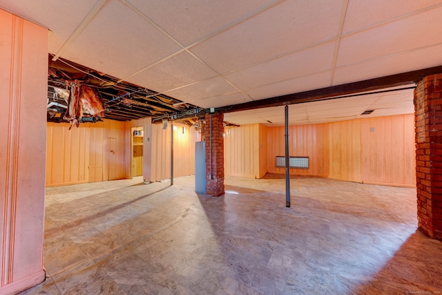 basement featuring wooden walls