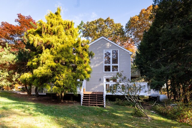 back of property with a lawn and a wooden deck