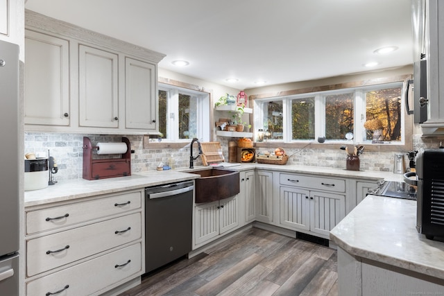 kitchen with sink, stainless steel appliances, dark wood-type flooring, white cabinets, and decorative backsplash