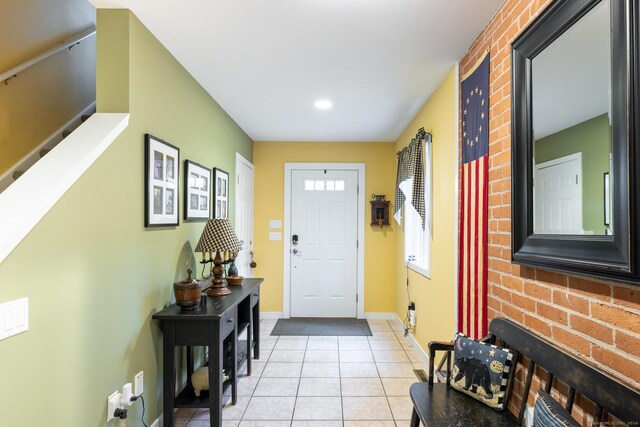 tiled foyer entrance with brick wall