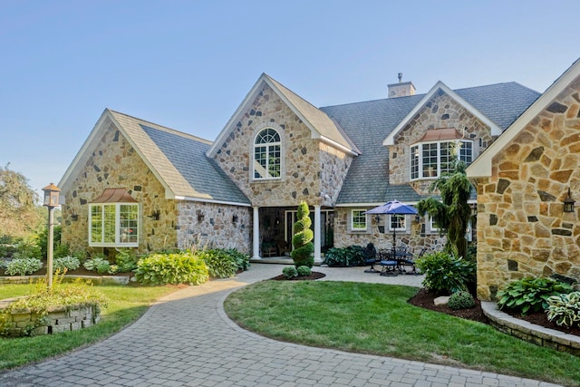 tudor-style house with a front lawn