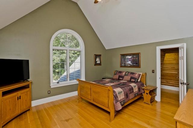 bedroom featuring ceiling fan, light hardwood / wood-style flooring, and high vaulted ceiling