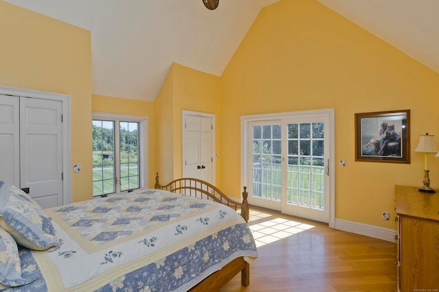 bedroom with light hardwood / wood-style flooring, high vaulted ceiling, a closet, and access to exterior