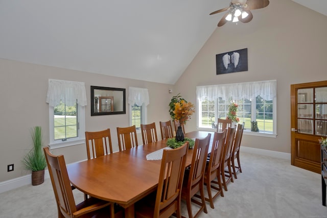 carpeted dining room featuring ceiling fan, high vaulted ceiling, and a healthy amount of sunlight