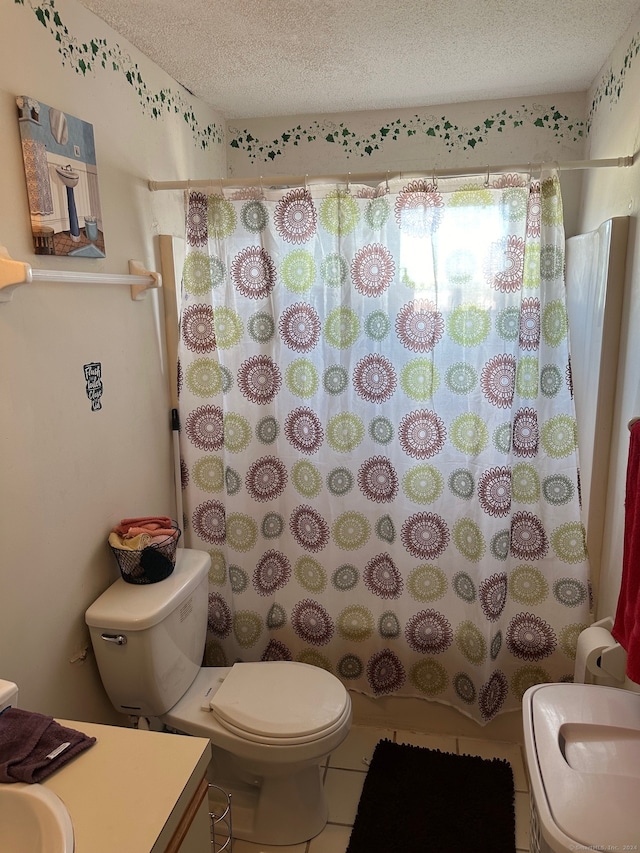 bathroom with vanity, a textured ceiling, tile patterned flooring, and toilet