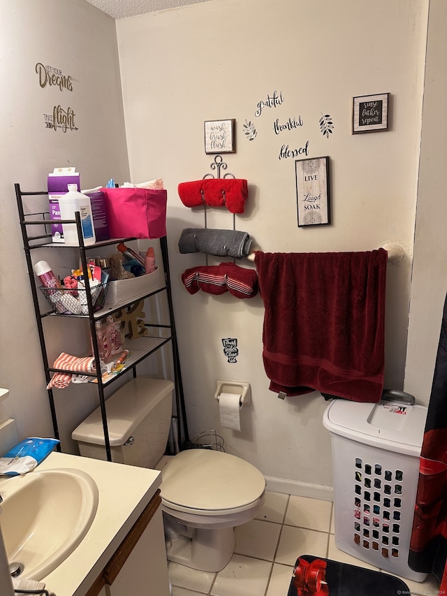 bathroom featuring tile patterned flooring, vanity, and toilet