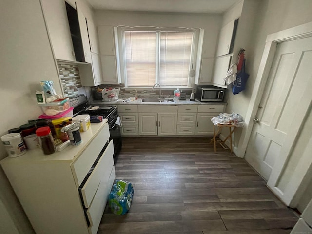 kitchen featuring dark hardwood / wood-style floors, tasteful backsplash, sink, white cabinets, and white range with electric cooktop