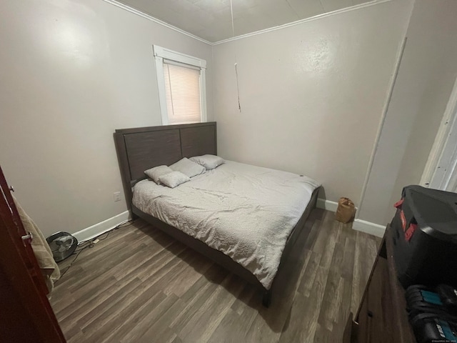 bedroom with ornamental molding and dark wood-type flooring