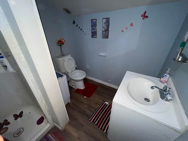 bathroom with a shower, vanity, toilet, and wood-type flooring