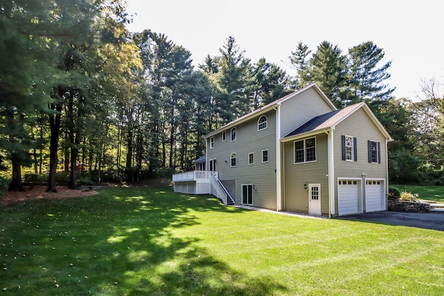 view of side of home featuring a lawn, a garage, and a deck