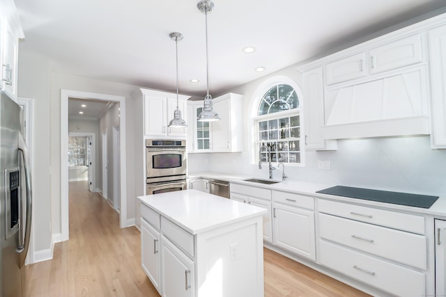 kitchen featuring a center island, white cabinetry, sink, and appliances with stainless steel finishes