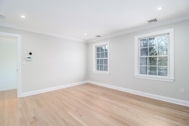 spare room featuring light hardwood / wood-style flooring and crown molding