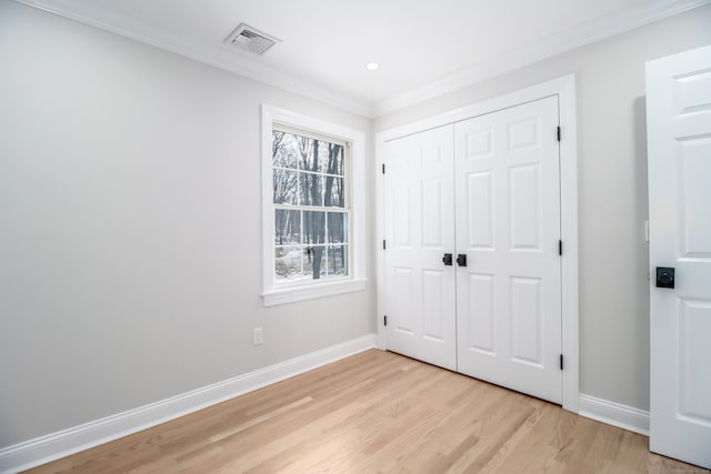 unfurnished bedroom featuring light hardwood / wood-style floors, a closet, and ornamental molding