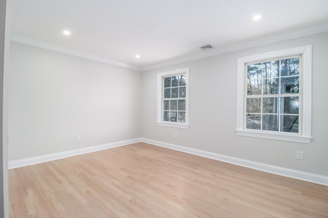 spare room with crown molding and light hardwood / wood-style flooring