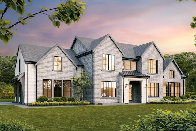 view of front facade featuring a front lawn, a standing seam roof, and roof with shingles