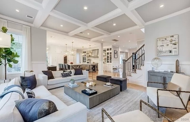 living room featuring a healthy amount of sunlight, beam ceiling, and coffered ceiling