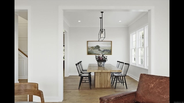 dining space featuring crown molding, baseboards, and light wood-style floors