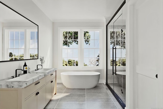 bathroom with ornamental molding, vanity, and a bath