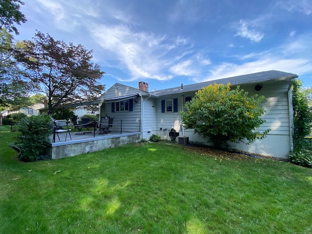 rear view of property with a lawn, cooling unit, and a deck