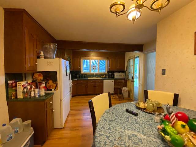 kitchen with sink, a chandelier, light hardwood / wood-style floors, and white appliances