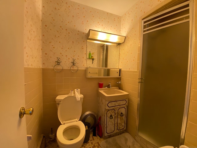 bathroom featuring tile walls, an enclosed shower, a baseboard radiator, vanity, and toilet