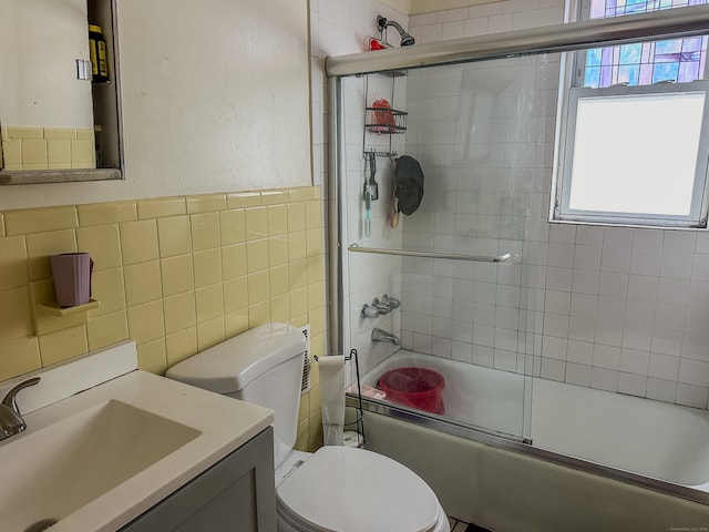 full bathroom featuring tile walls, vanity, enclosed tub / shower combo, and toilet