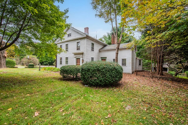 rear view of property featuring a yard