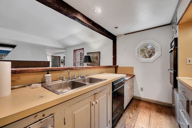 kitchen featuring light hardwood / wood-style flooring, cream cabinetry, sink, and black appliances