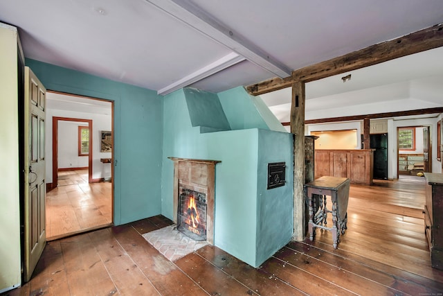 living room featuring beam ceiling and dark hardwood / wood-style floors