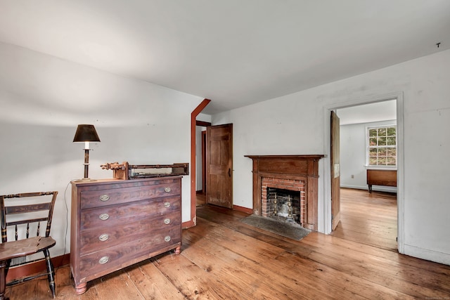 living room with light hardwood / wood-style flooring and a brick fireplace