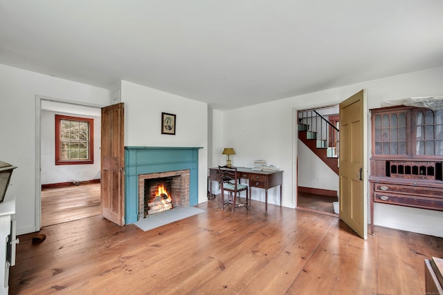 living room featuring light hardwood / wood-style flooring and a brick fireplace