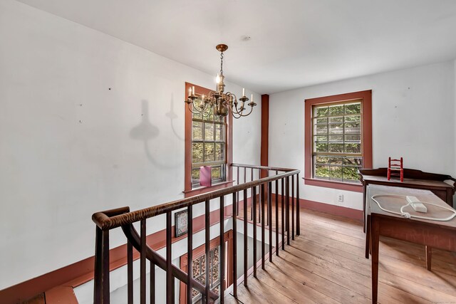 hall with an inviting chandelier and light hardwood / wood-style floors