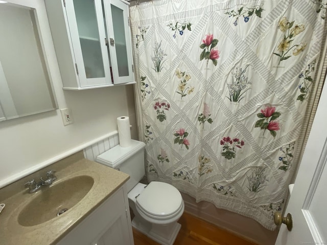 full bathroom with shower / bath combo with shower curtain, vanity, hardwood / wood-style floors, and toilet