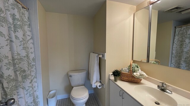 bathroom with tile patterned floors, curtained shower, vanity, and toilet