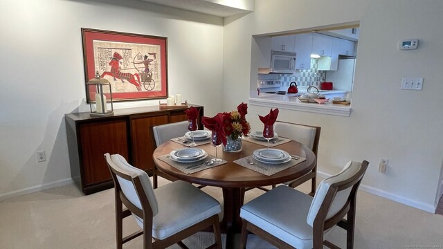 dining area featuring light carpet