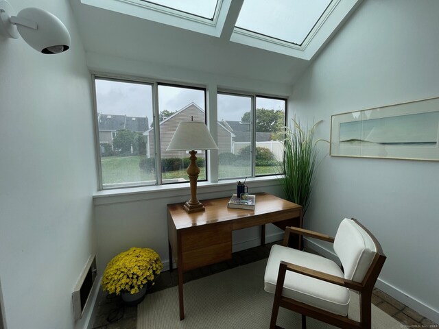 living area with vaulted ceiling with skylight