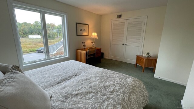 bedroom with a closet and dark colored carpet