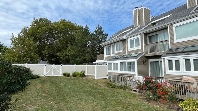 view of yard with central AC unit and a sunroom