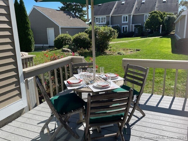 wooden deck featuring a lawn