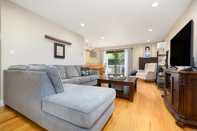 living room featuring light wood-type flooring and a wall mounted AC